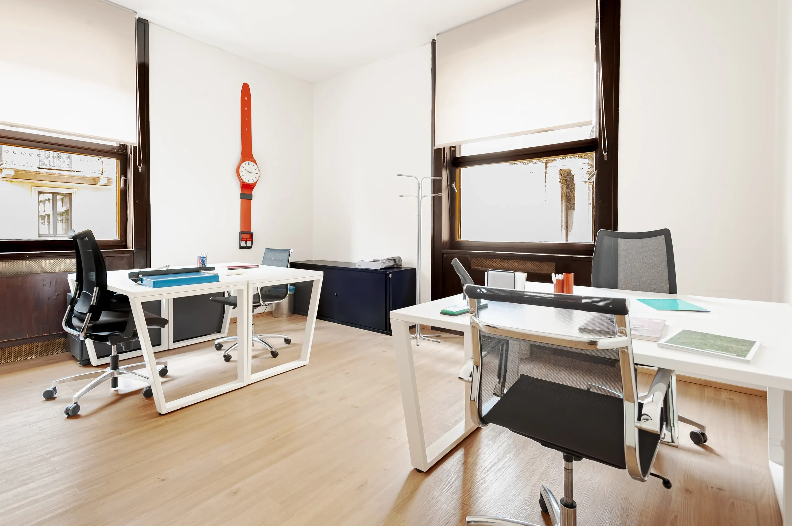 Private office with two desks and tall windows