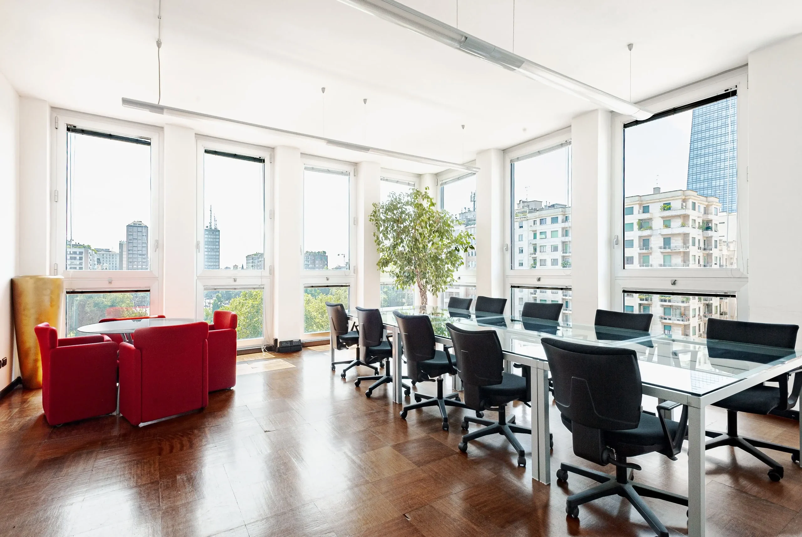 Office with long glass desk and city views